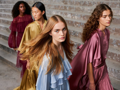 AI Fashion Four women in colorful dresses standing on a staircase.