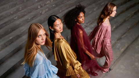 AI Fashion -Four women in stylish dresses standing on a staircase.