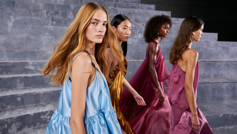 ai Fashion-Four women in colorful dresses standing on stone steps.